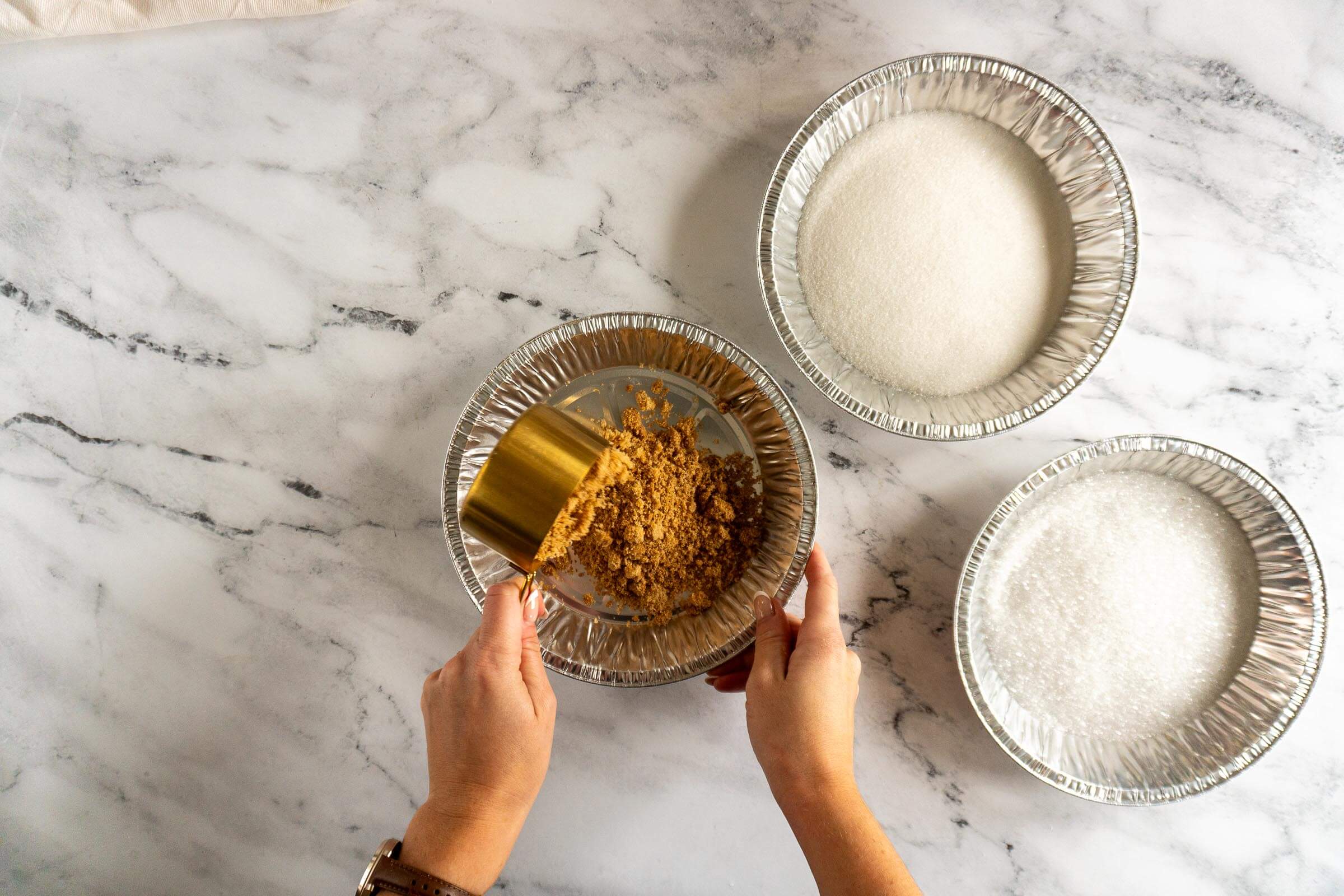 Adding brown sugar to a pie plate.