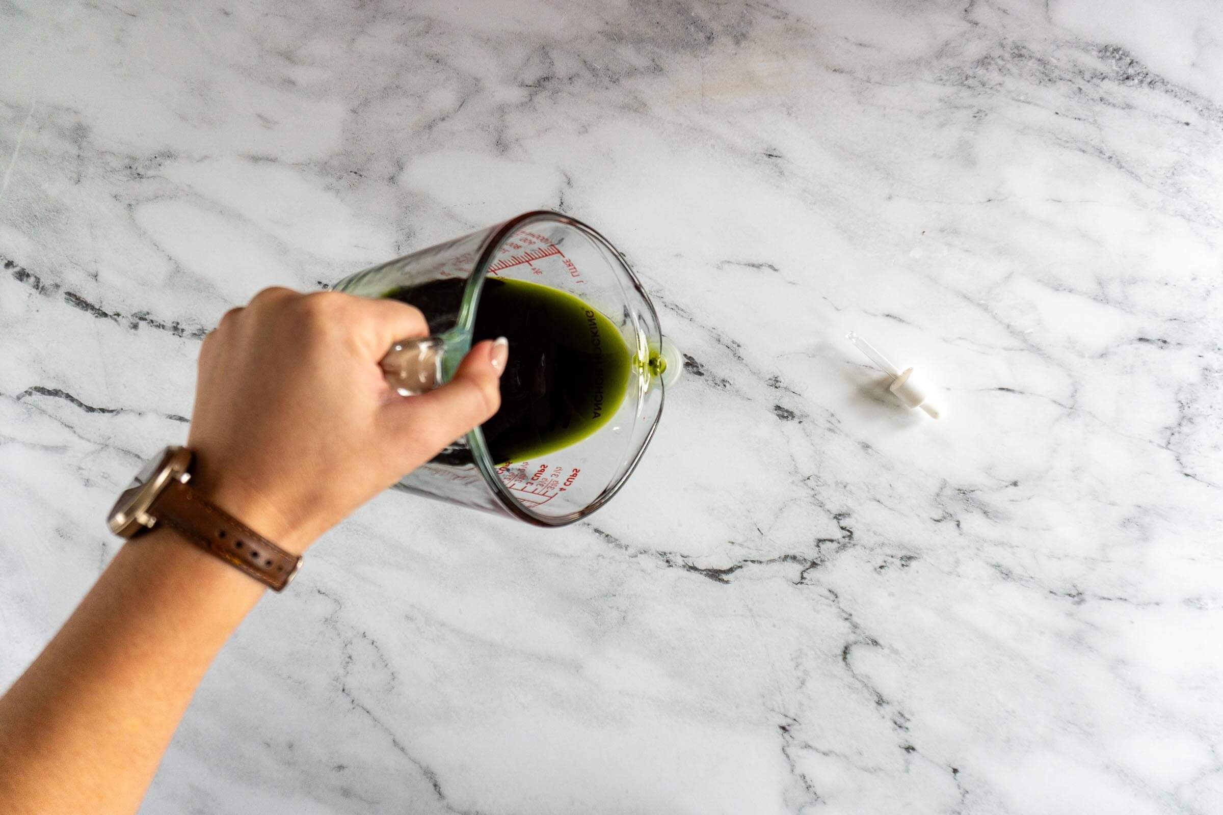 Casting homemade mint extract into a small bottle.