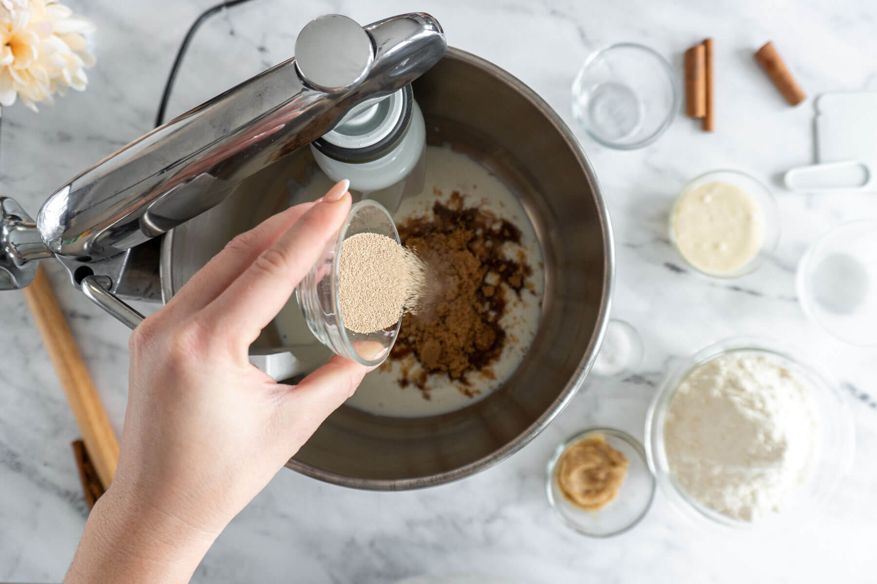 Adding yeast to the bowl of a stand mixer. 