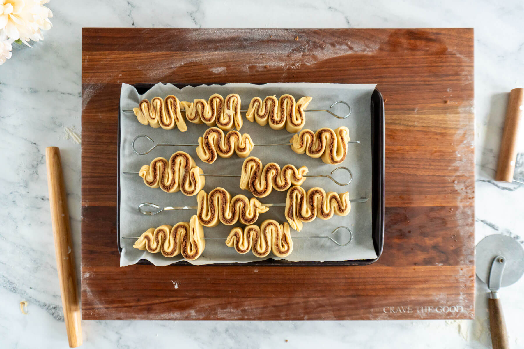 Cinnamon roll Christmas trees on baking sheet.