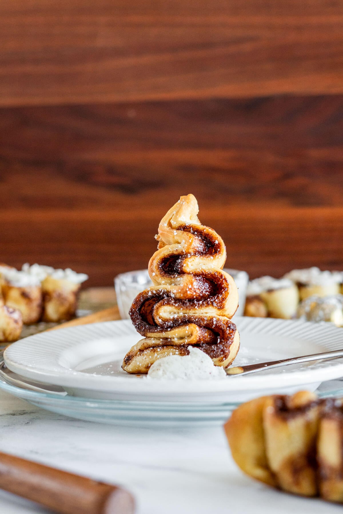 Cinnamon roll Christmas tree standing on a plate.