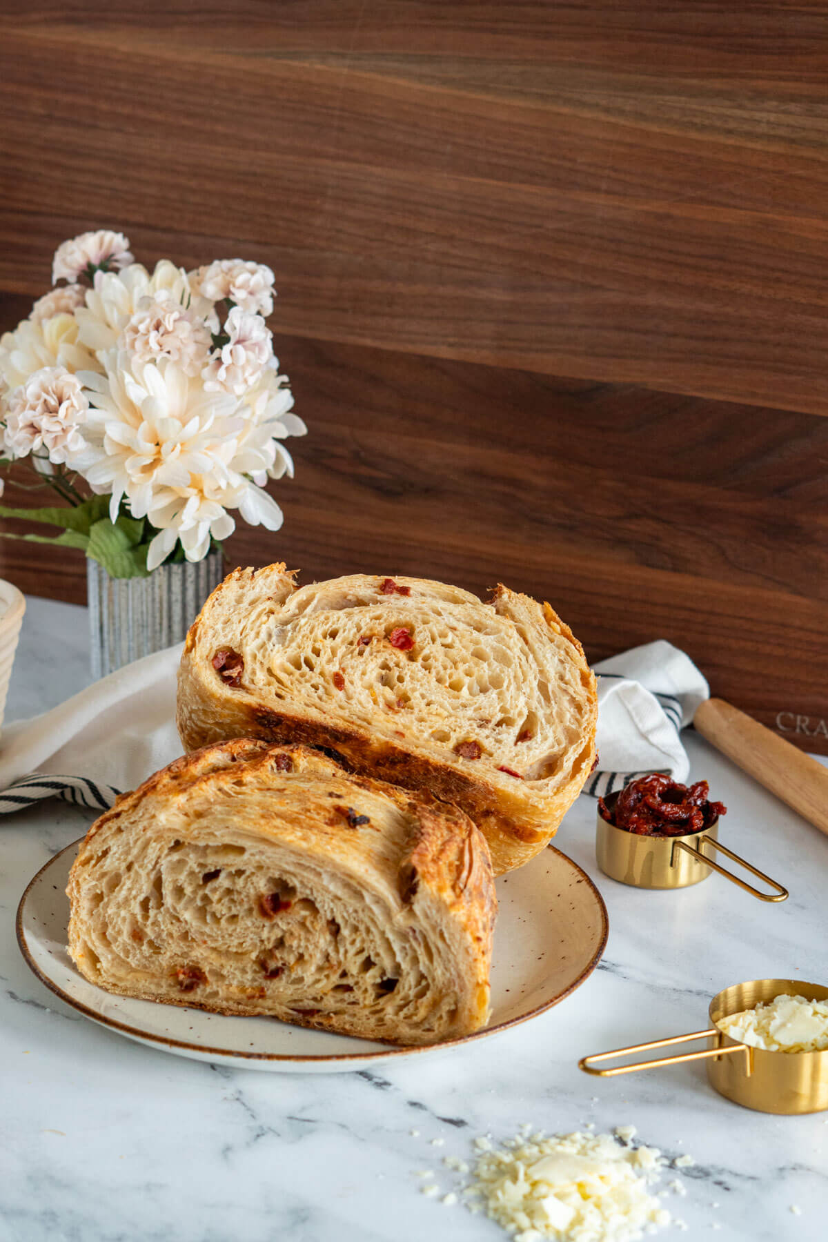 Sun dried tomatoes sourdough bread loaf sliced in half.