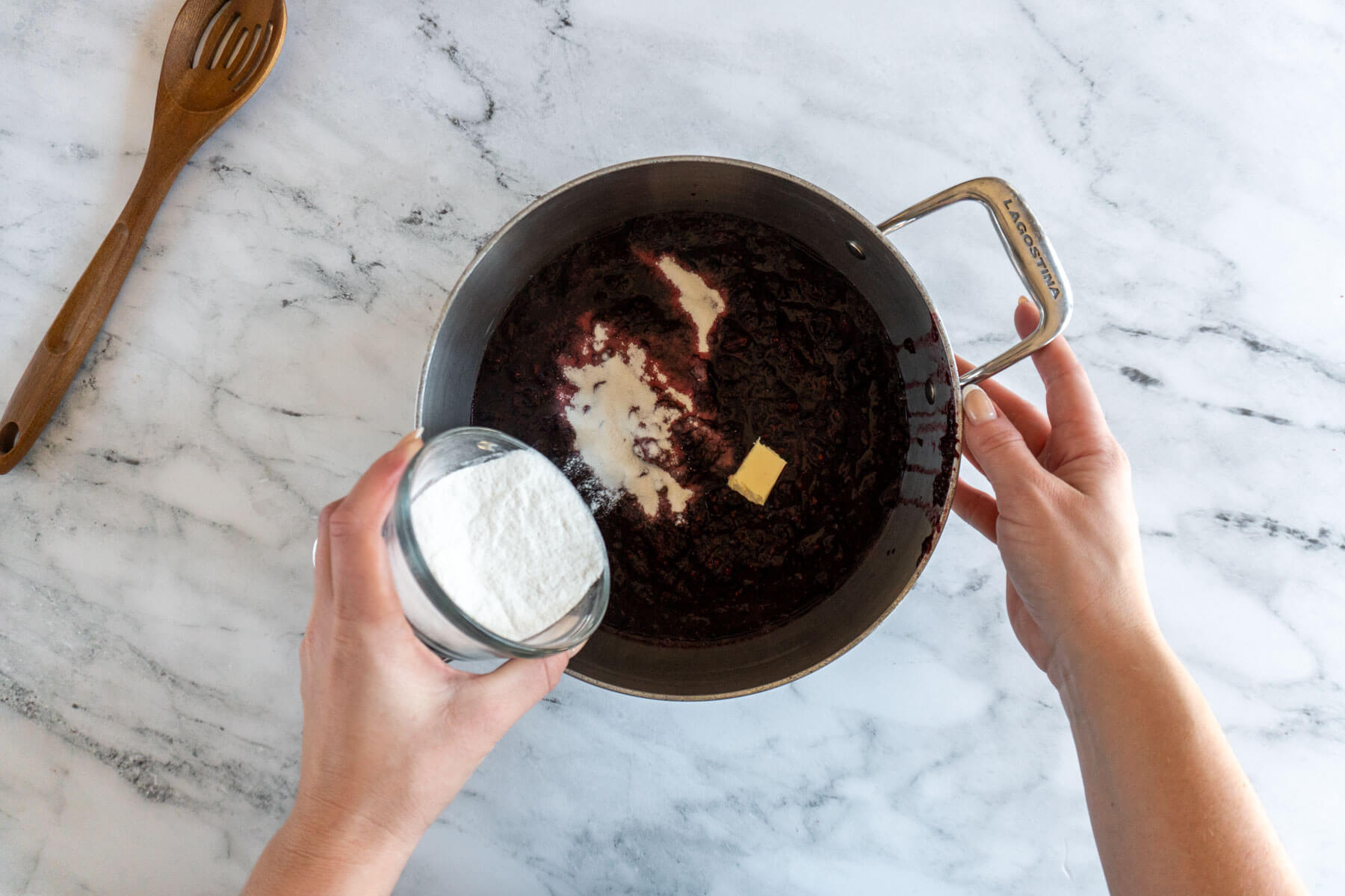 Adding pectin crystals and butter to the berries. 