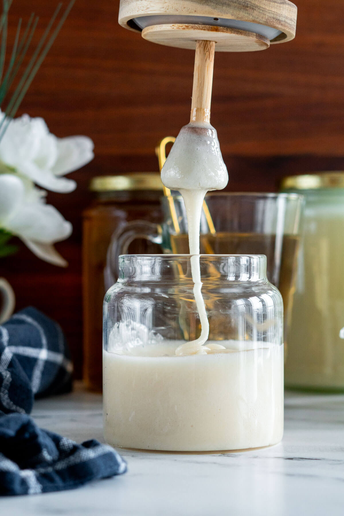 Creamed honey drizzling from honey dripper. 