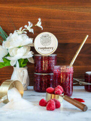 Raspberry jam in jars with fresh raspberries.
