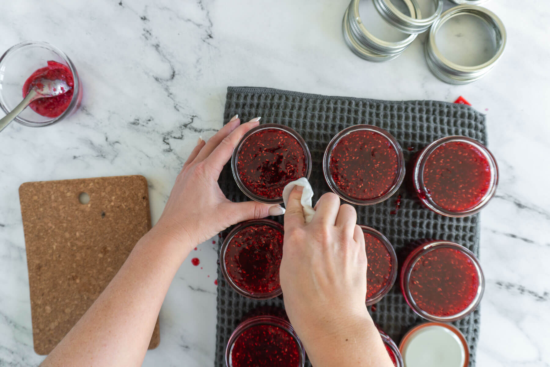 Wiping rims of jam jars.