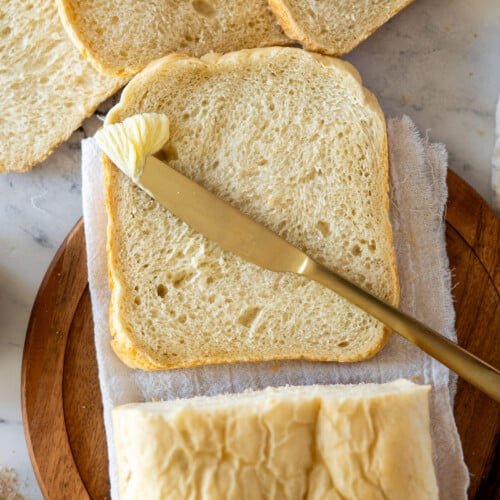 Sliced bread machine sourdough bread with a pat of butter.