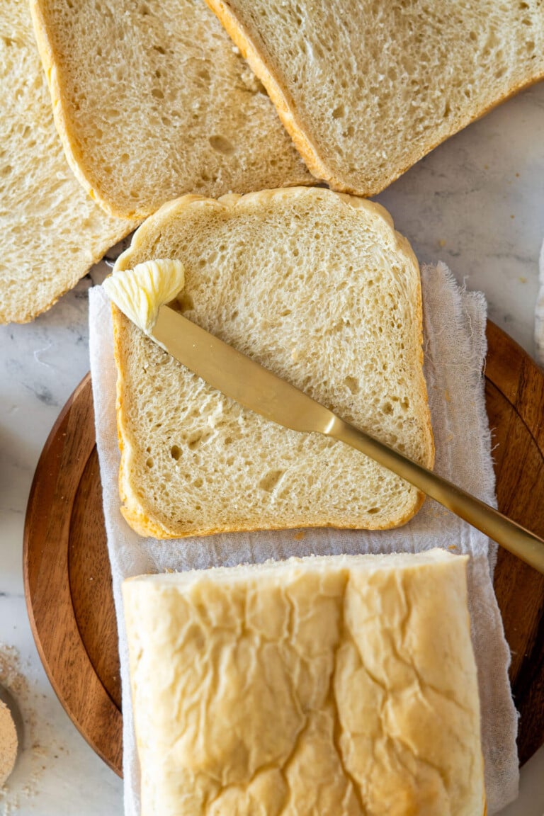 Sliced bread machine sourdough bread with a pat of butter.