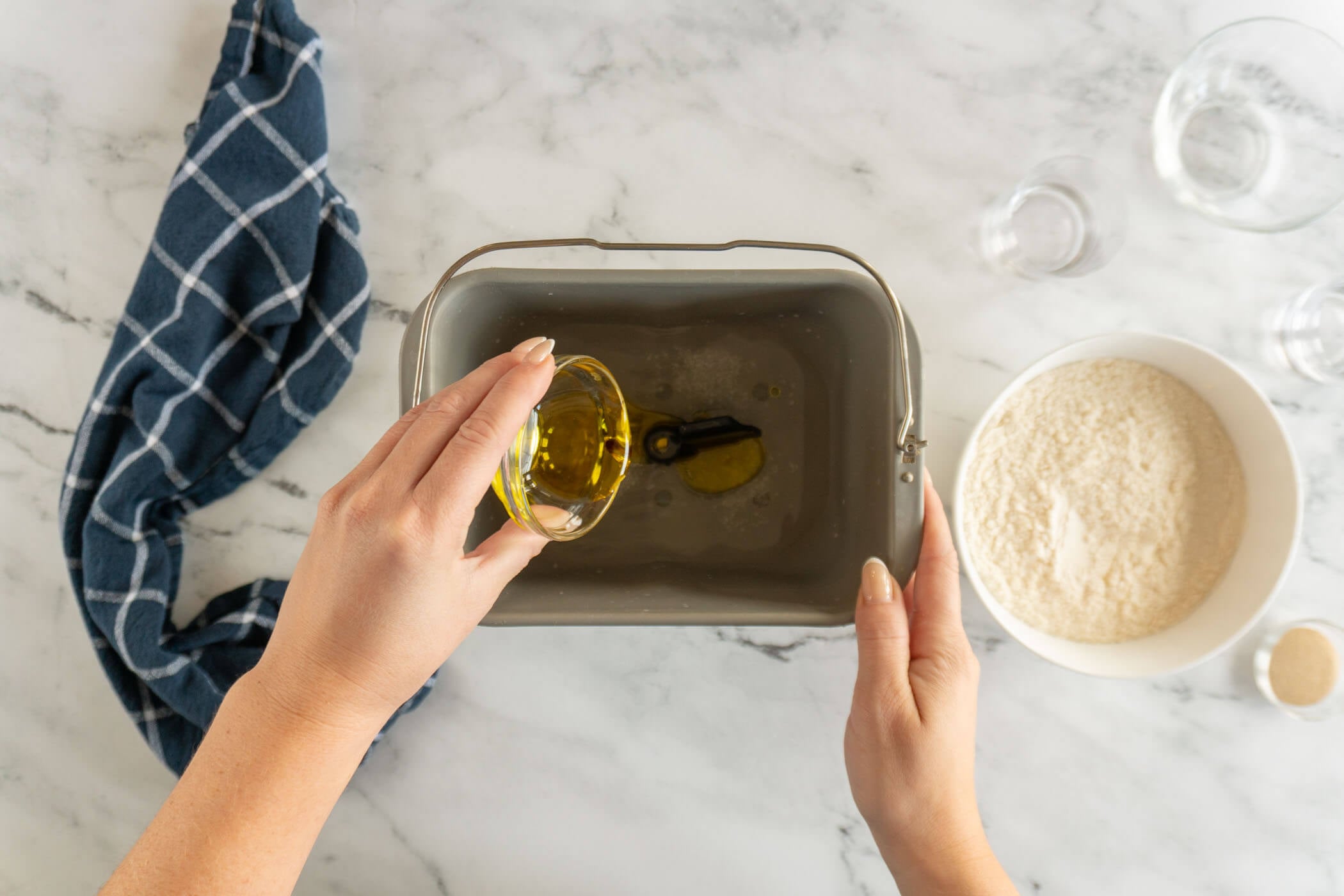 Adding liquid ingredients to bread pan. 