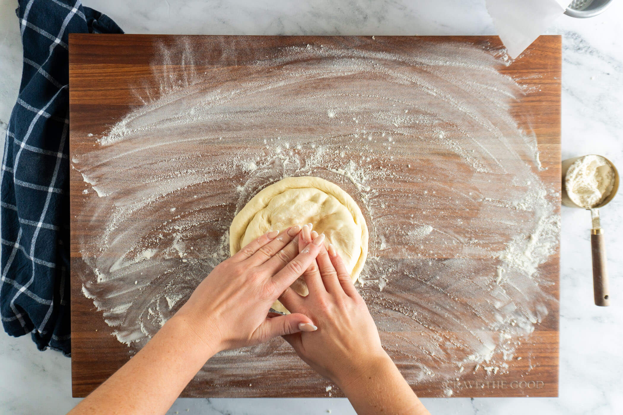 Pressing down the dough to shape the pizza. 