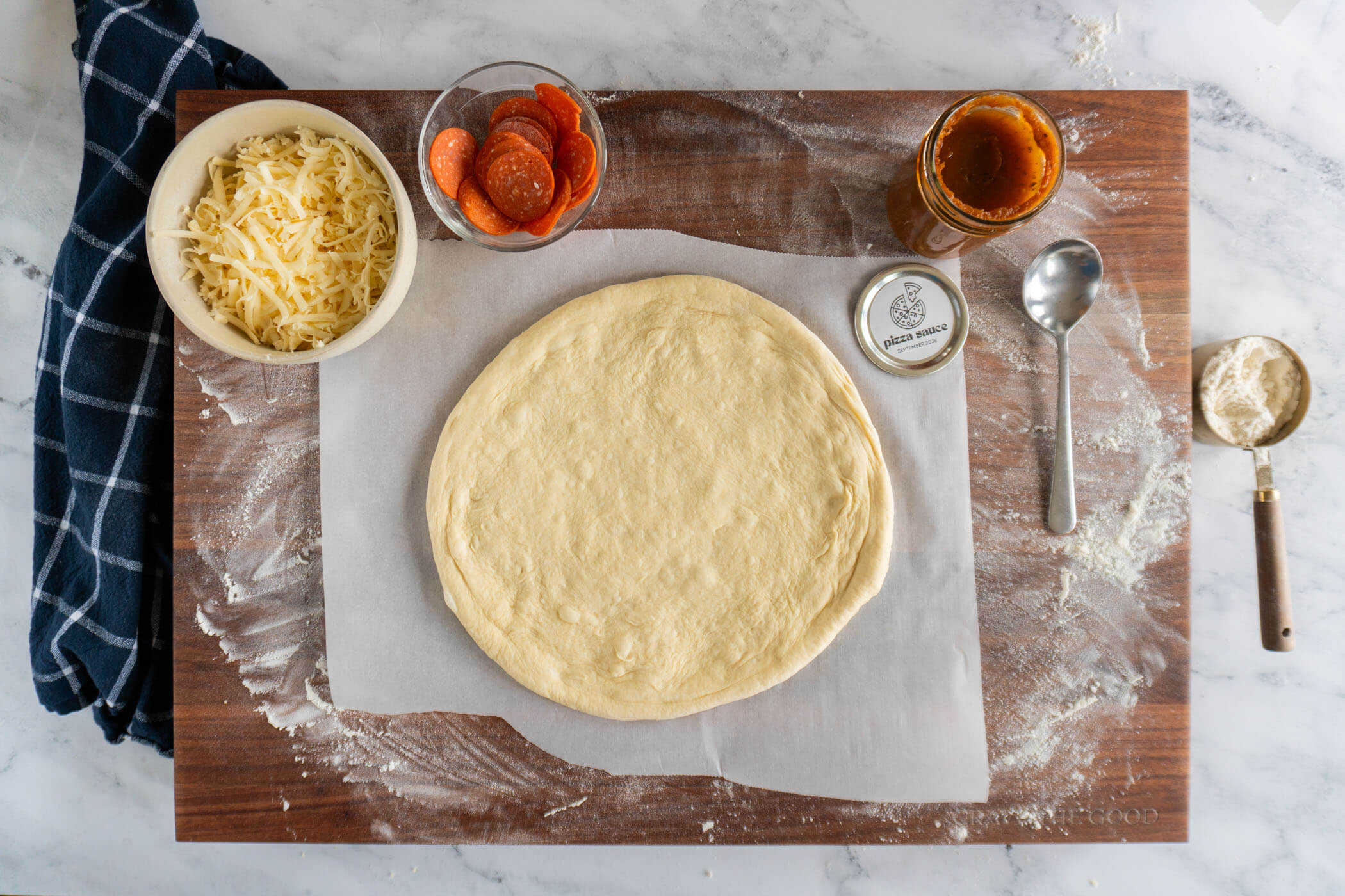 Prepared pizza crust on parchment paper. 