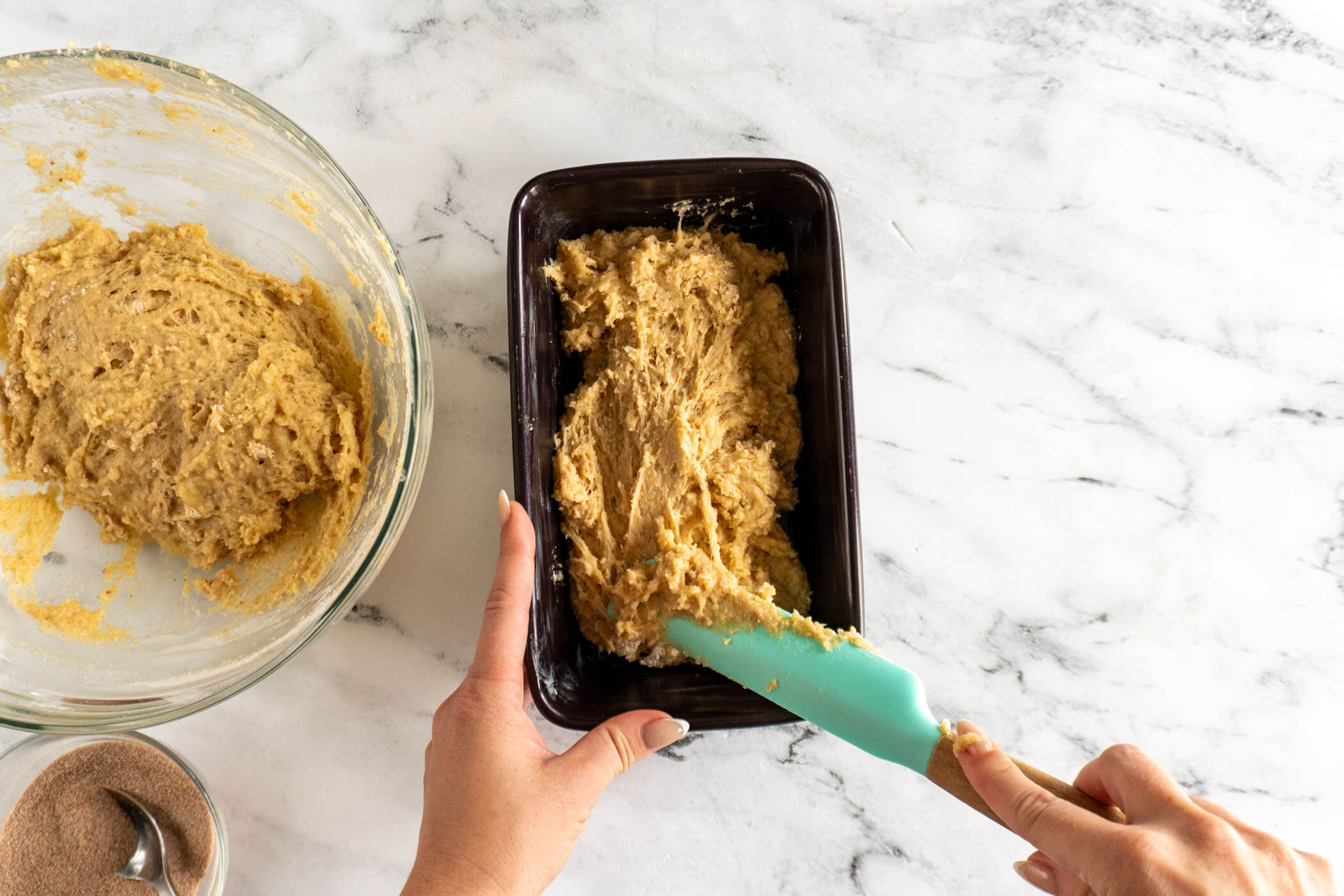 Spooning batter into the bottom of the pan. 