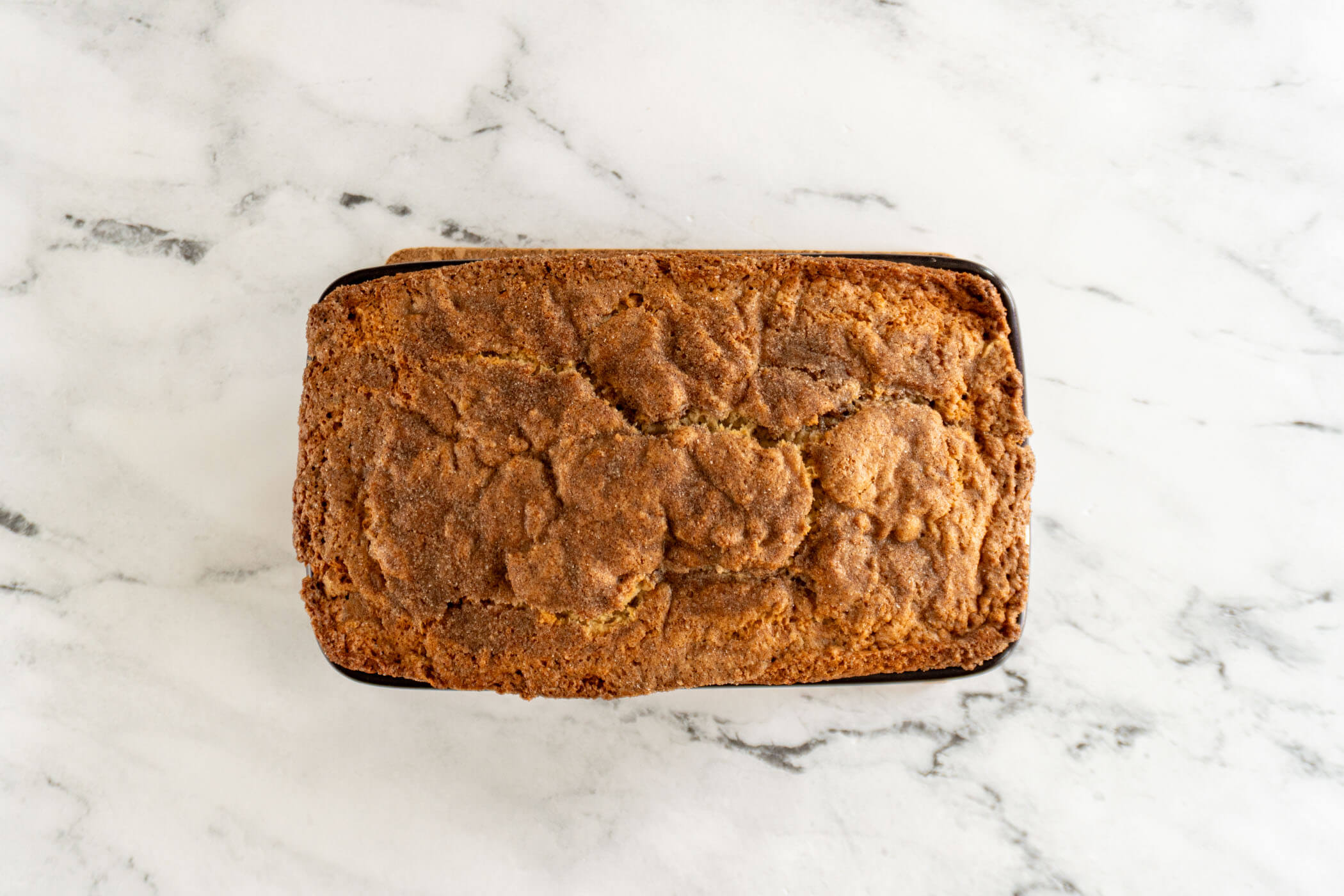 Baked sourdough discard cinnamon swirl quick bread on a trivet. 