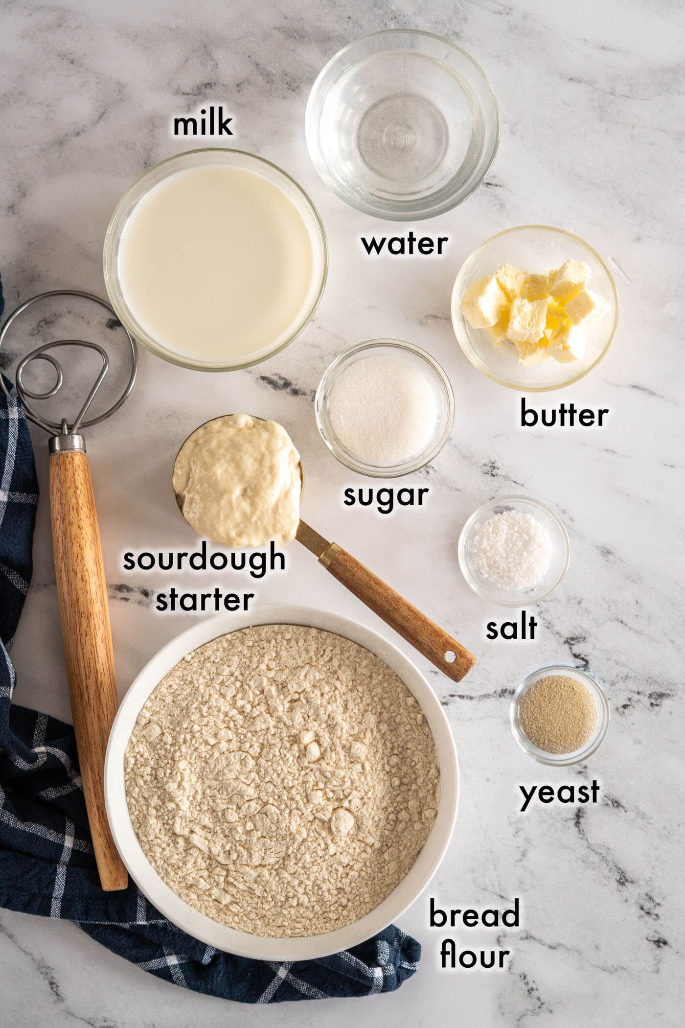 Ingredients for sourdough hot dog buns o marble counter. 