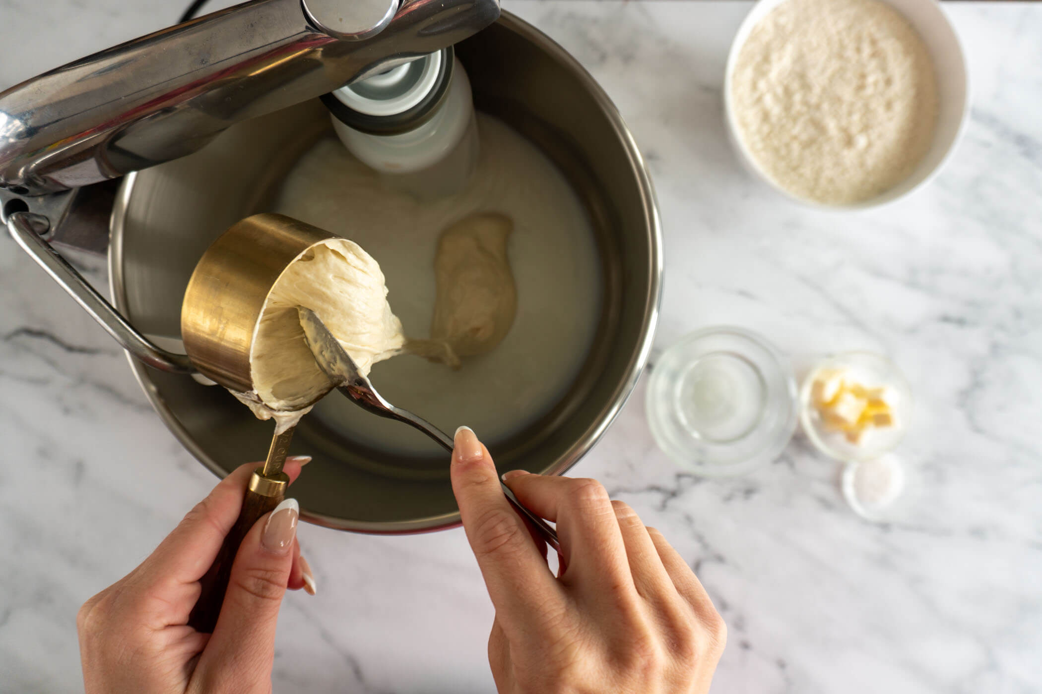 Adding sourdough starter to mixer. 