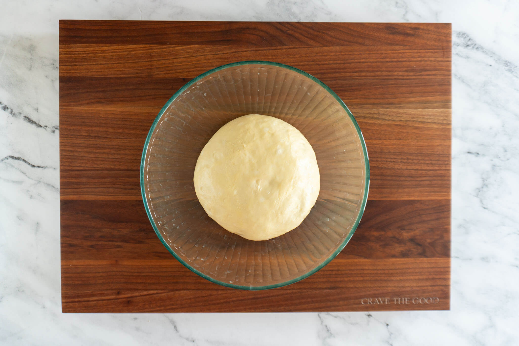 Dough doubled in a glass bowl. 