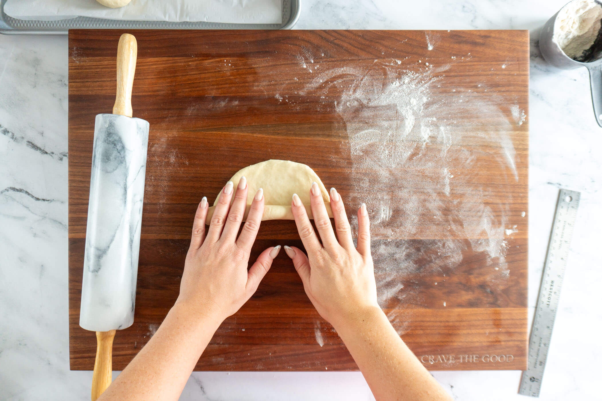Rolling the dough into a cylinder. 