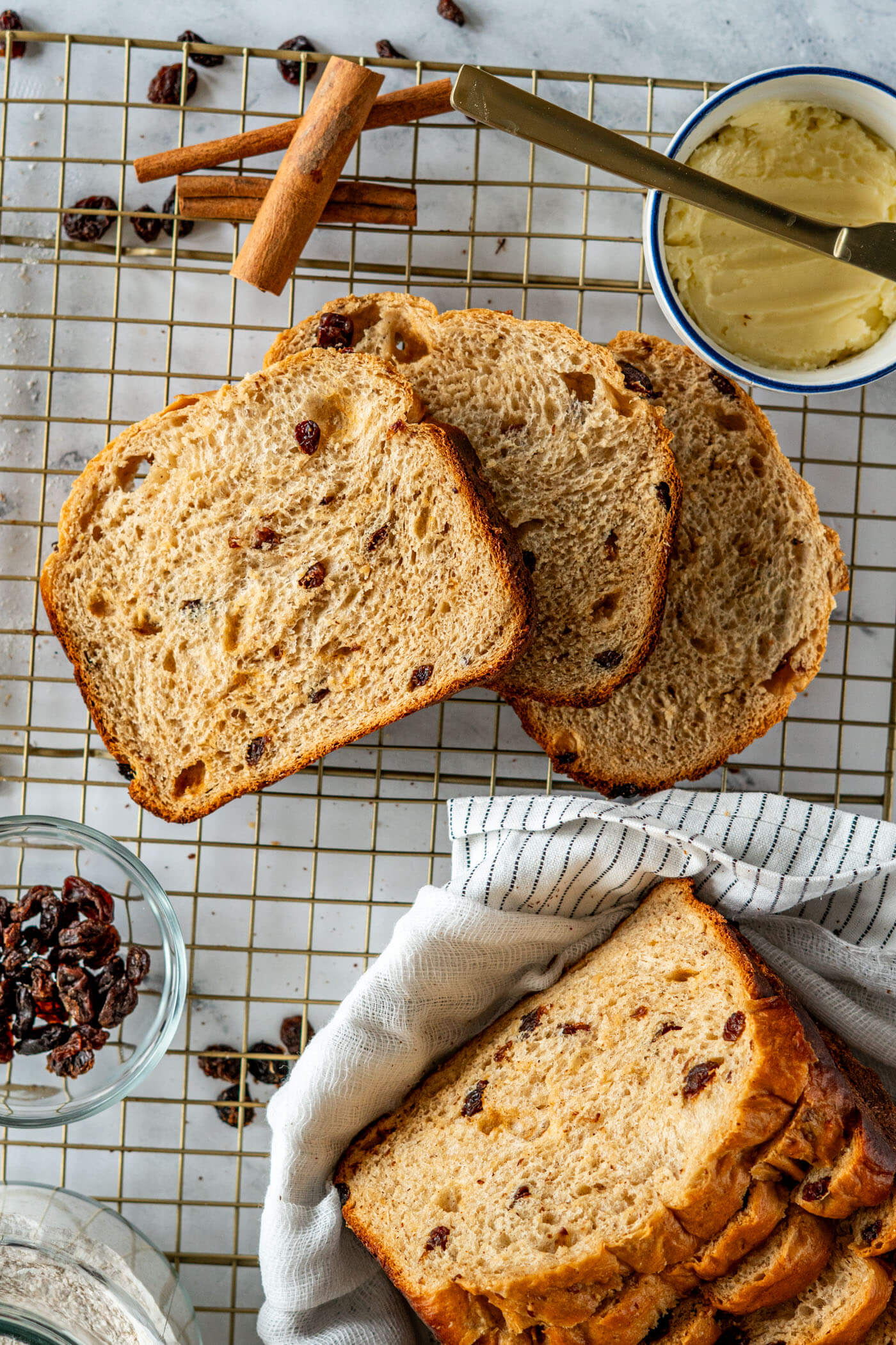 Sliced bread maker cinnamon raisin bread on a wire cooling rack. 