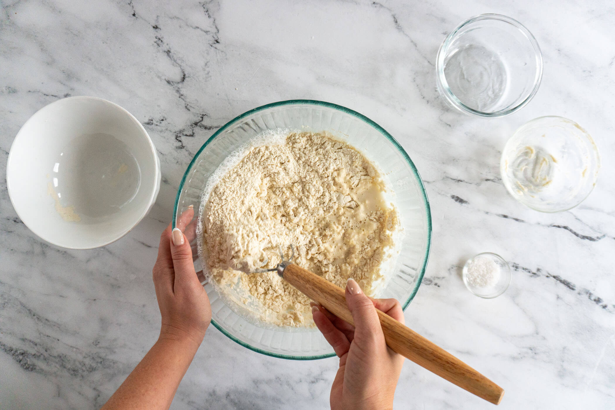 Mixing in the flour with a danish dough whisk.