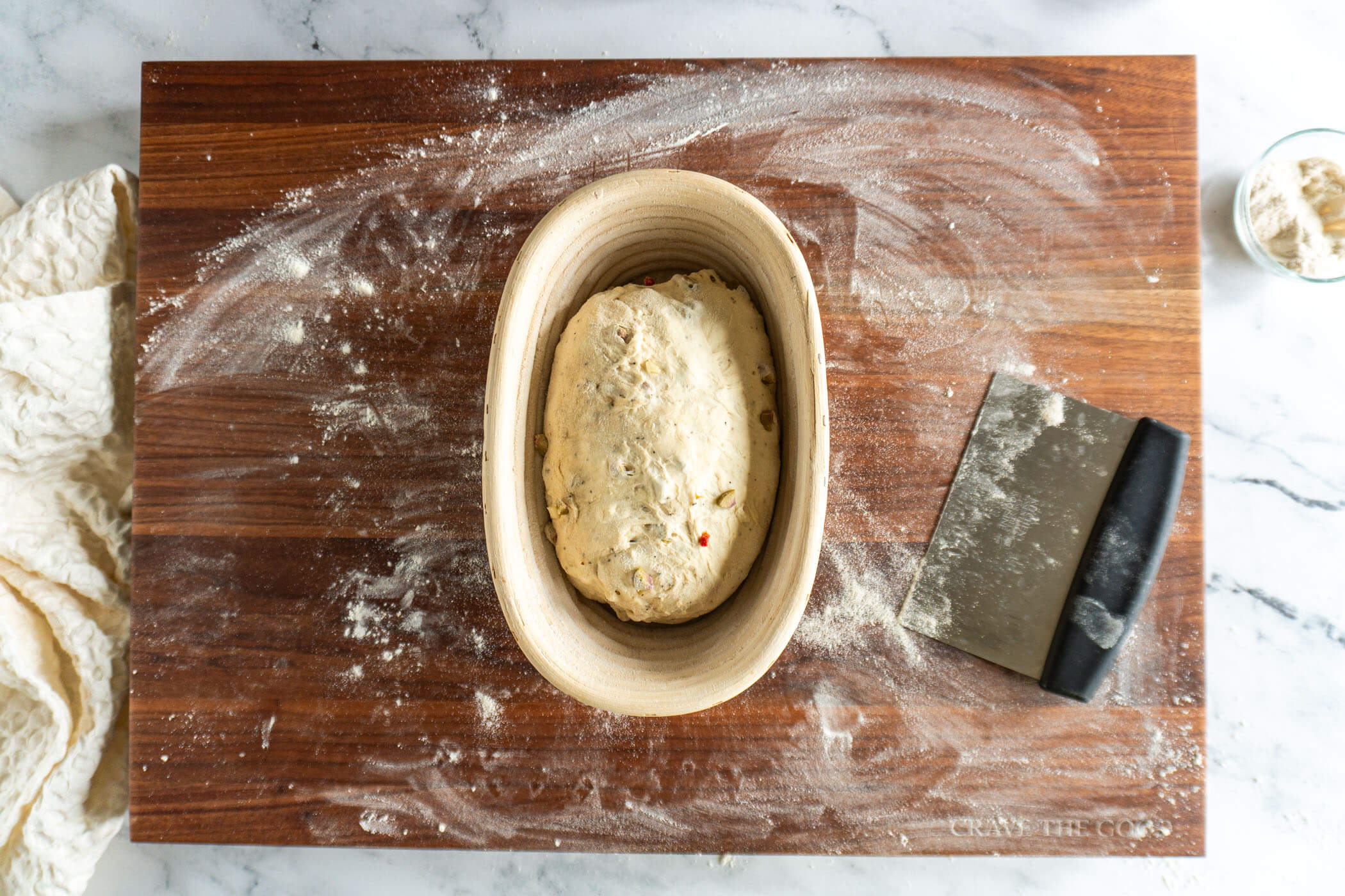 Olive sourdough loaf in banneton before proofing.