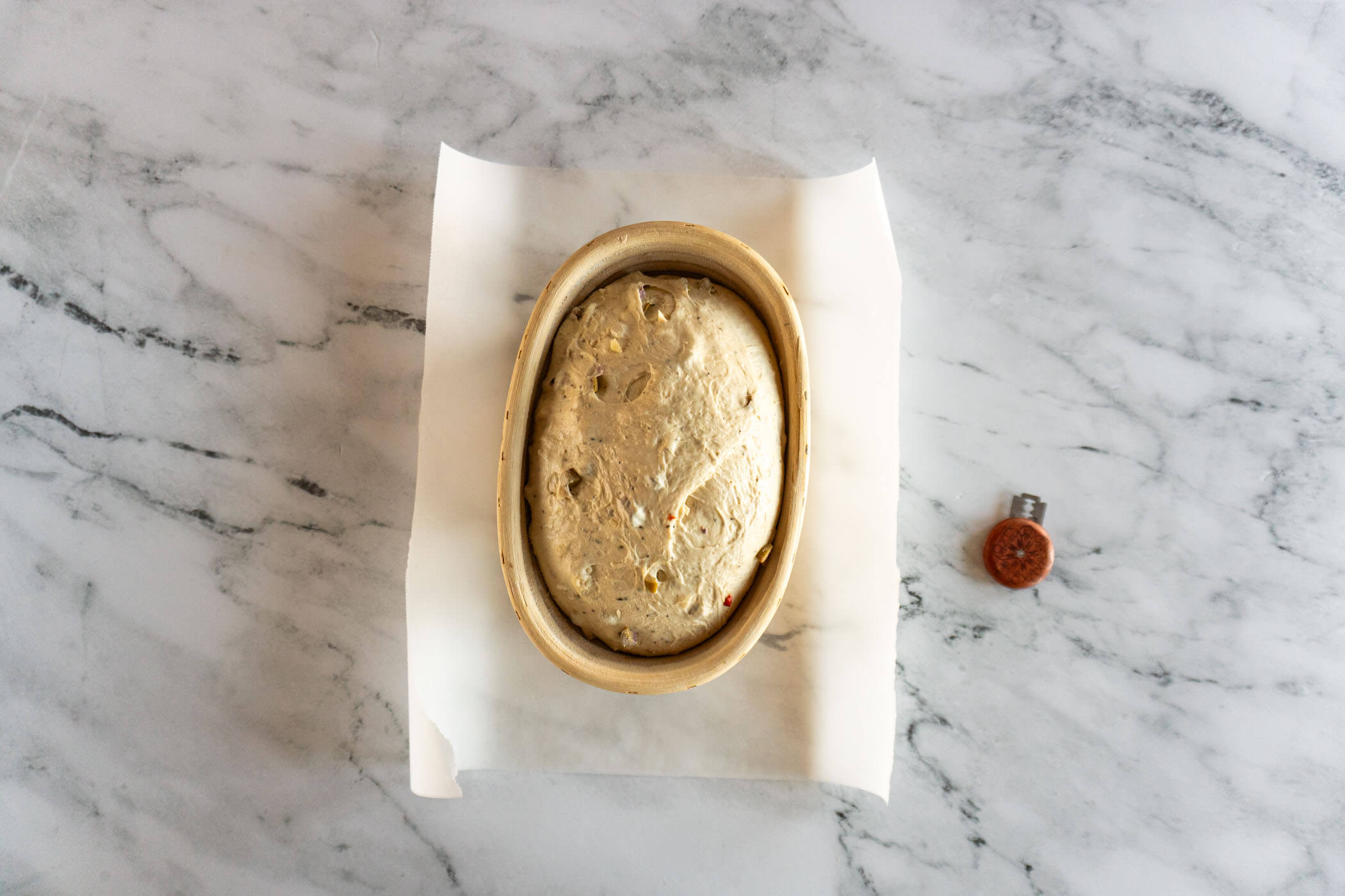 Sourdough olive bread in banneton after proofing.