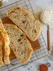 Sliced garlic olive sourdough vbread on a wire cooling rack.