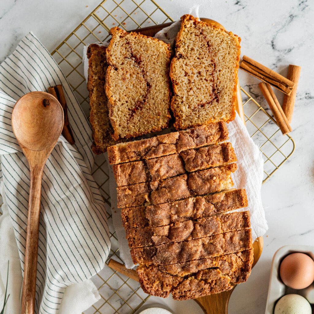 Sliced sourdough discard cinnamon quick bread on cutting board.