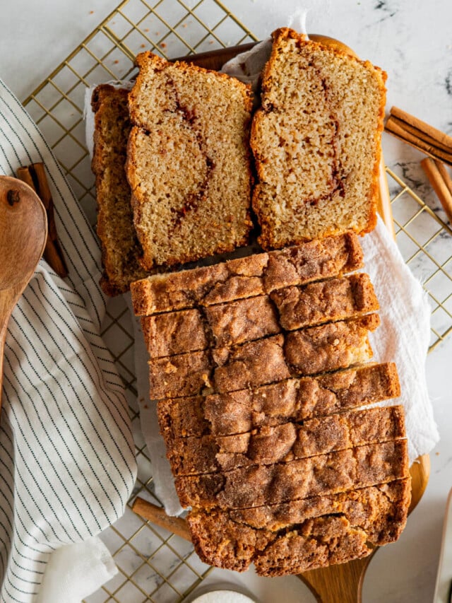 Sliced sourdough discard cinnamon quick bread on cutting board.
