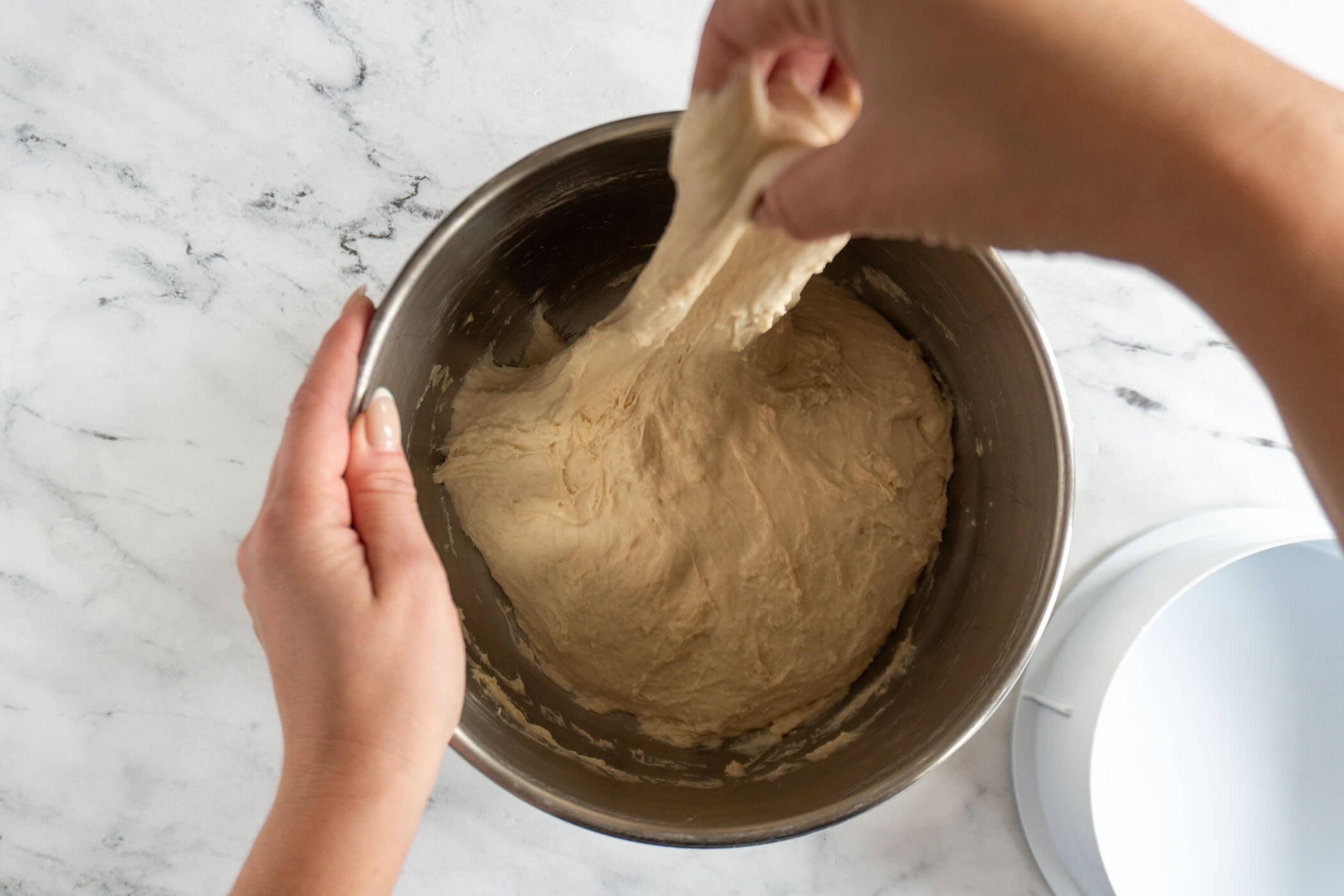 Stretching the dough in the mixing bowl. 