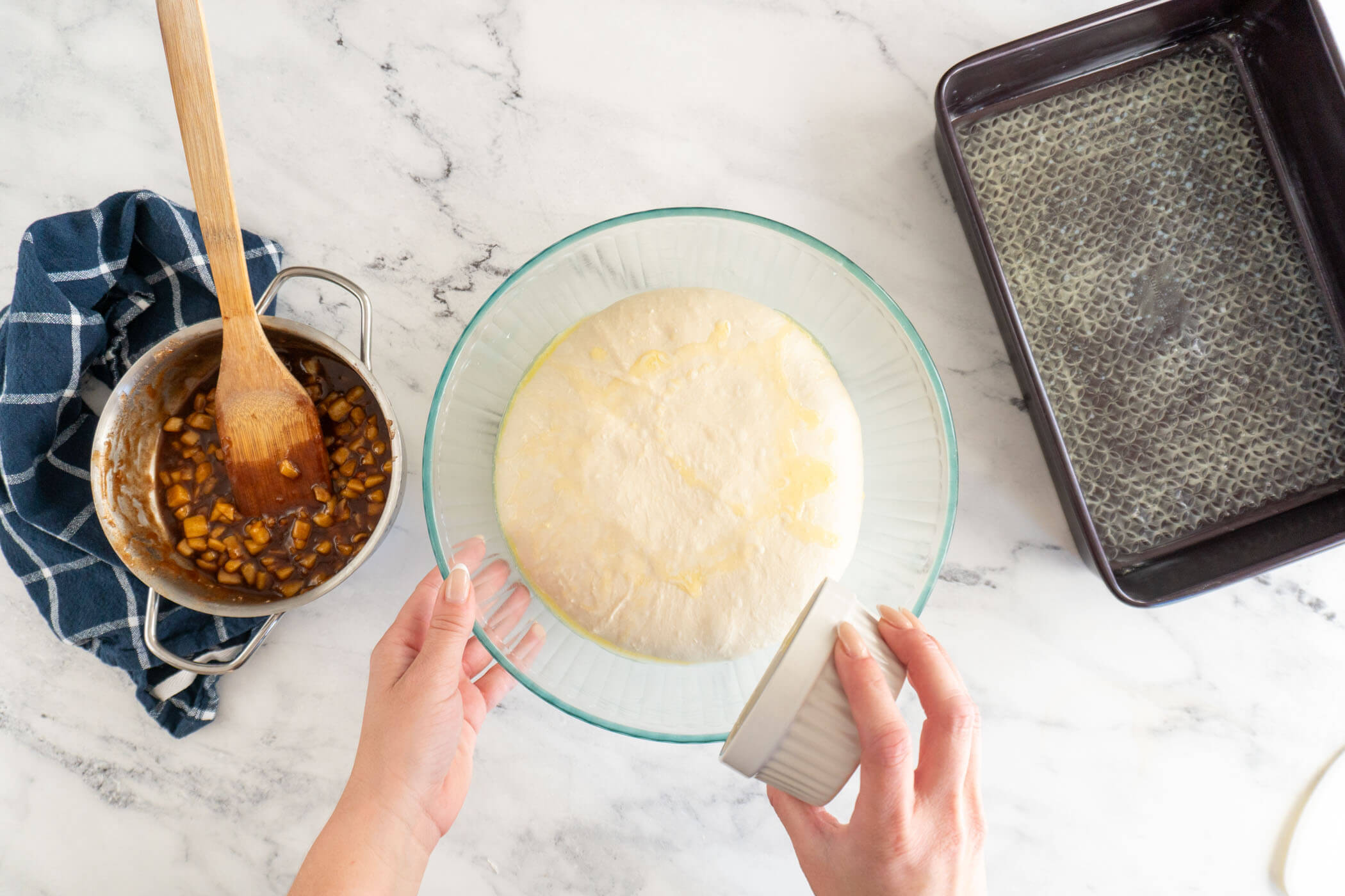 Pouring melted butter on dough. 