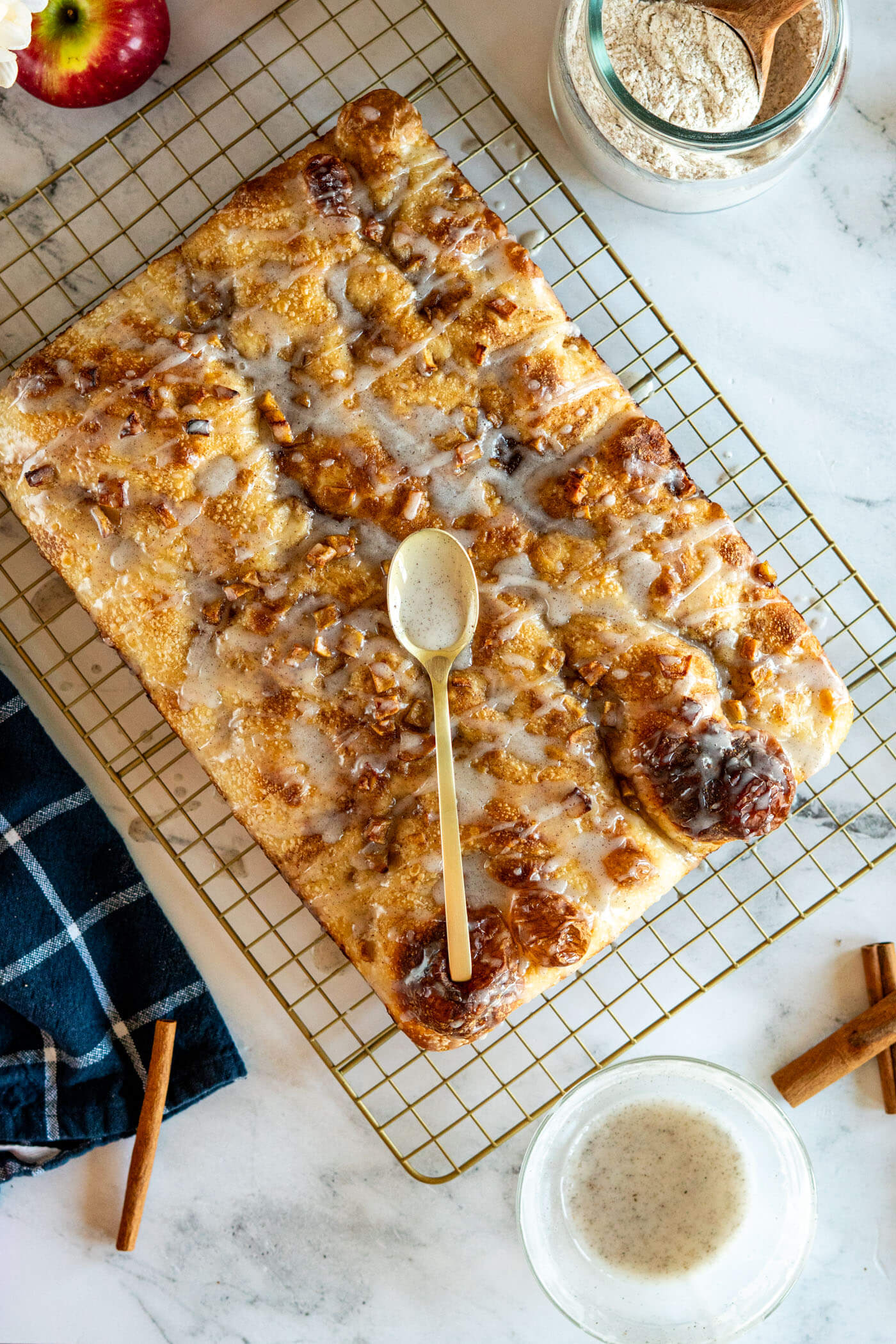 Whole loaf of sourdough focaccia with a spilling spoon of vanilla bean glaze. 