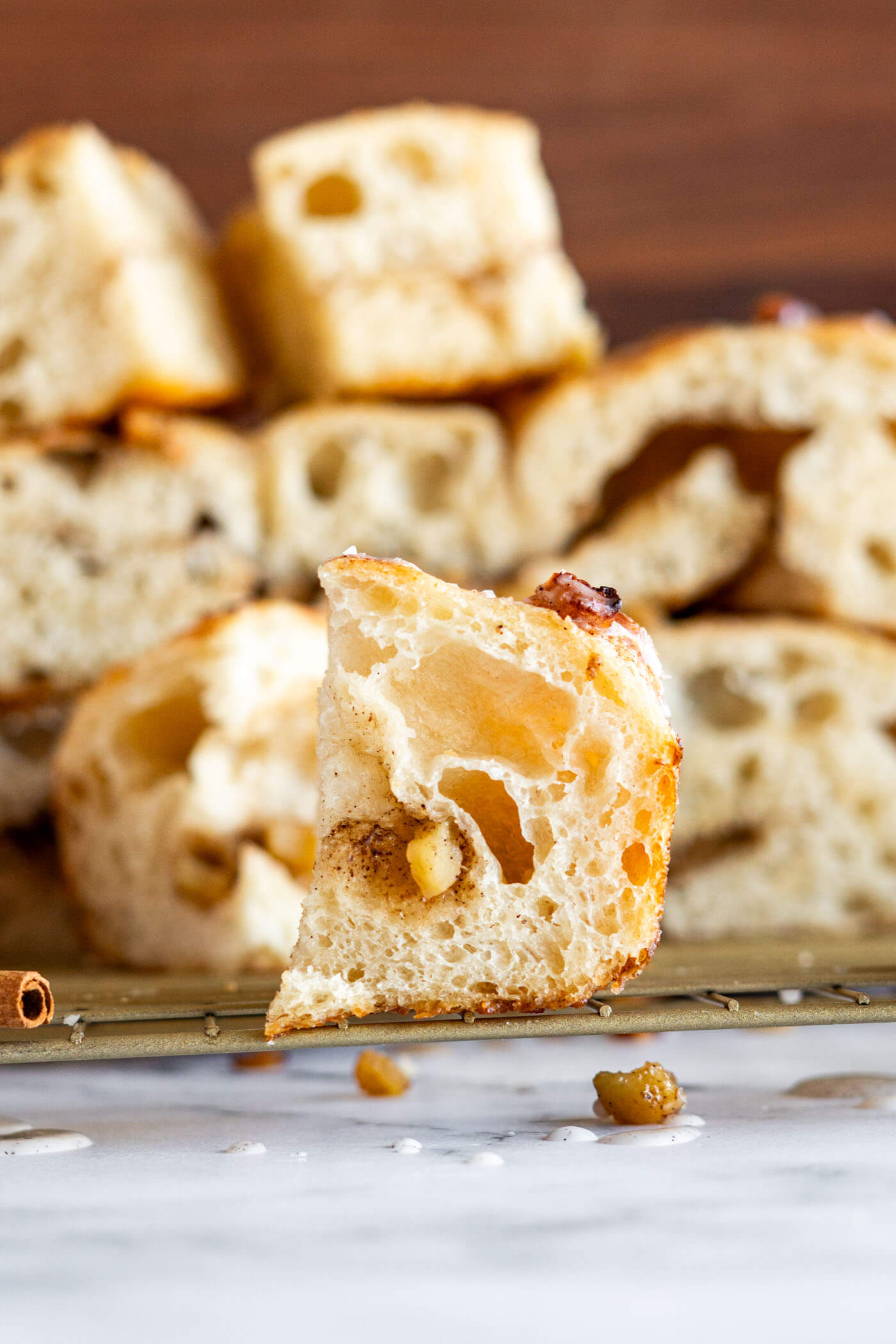 Square slice of apple cinnamon focaccia on a gold cooling rack. 