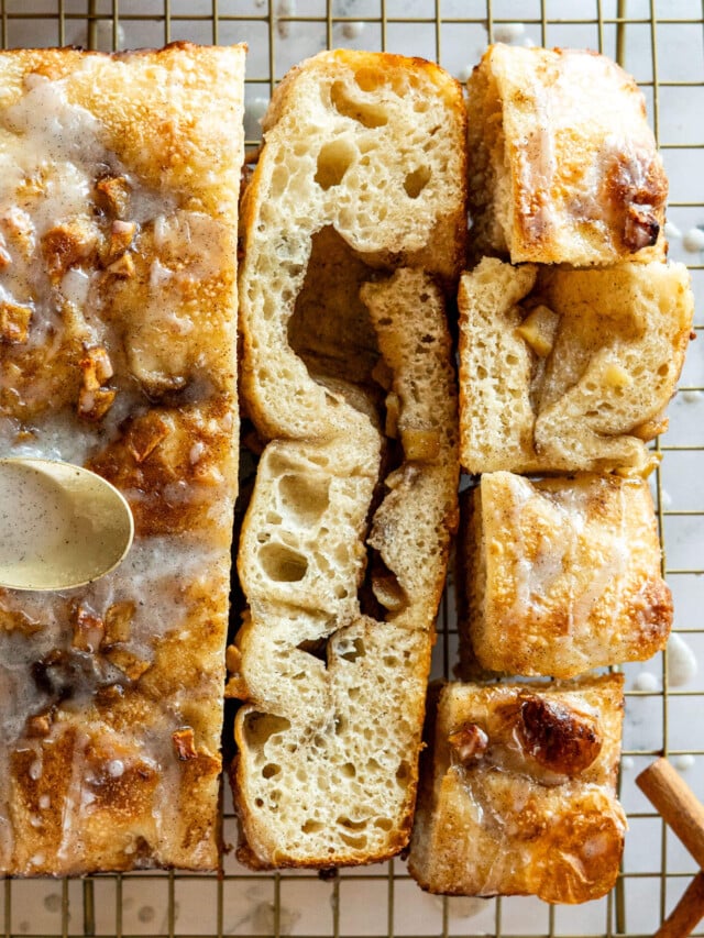 Sliced sourdough apple fritter focaccia with vanilla bean glaze.