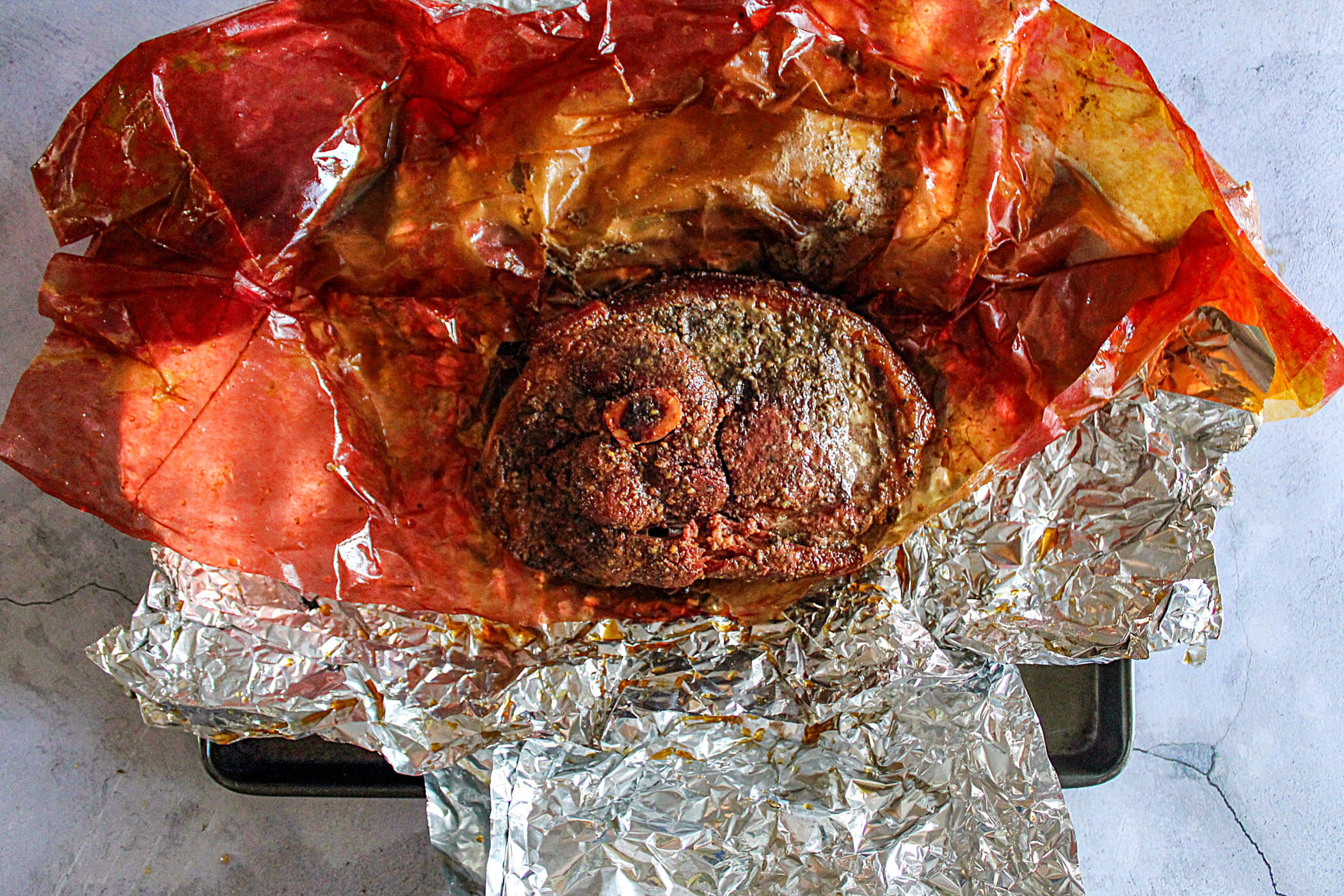 Wrapped and rested smoked pork picnic.