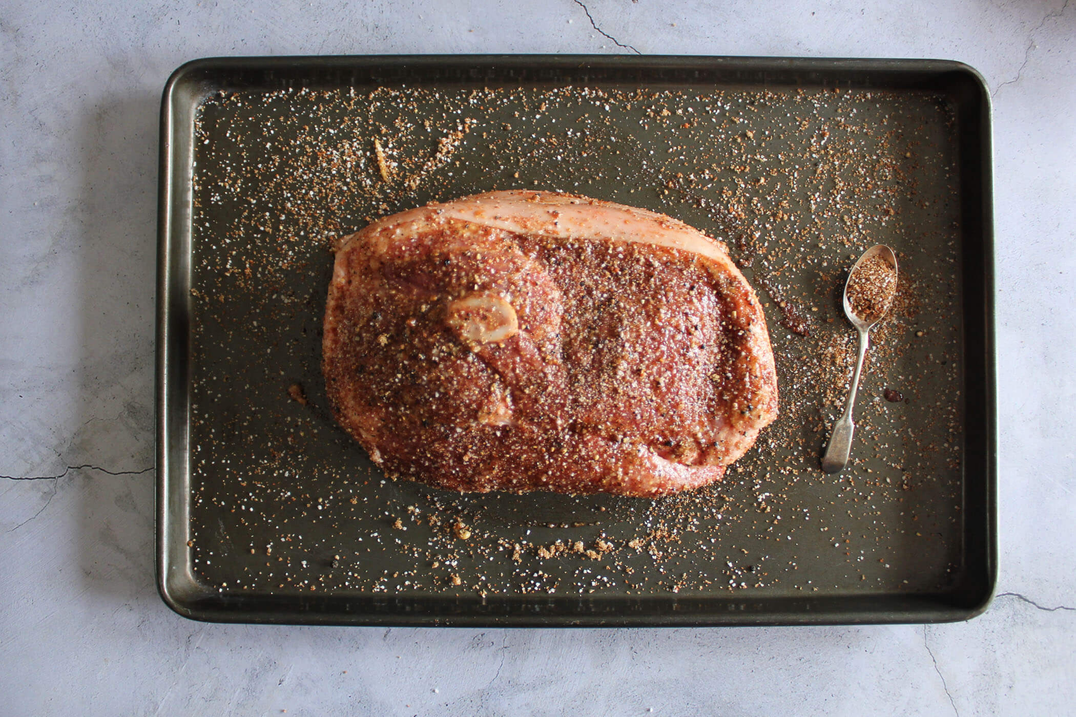 Pork picnic roast fully coated in rub.