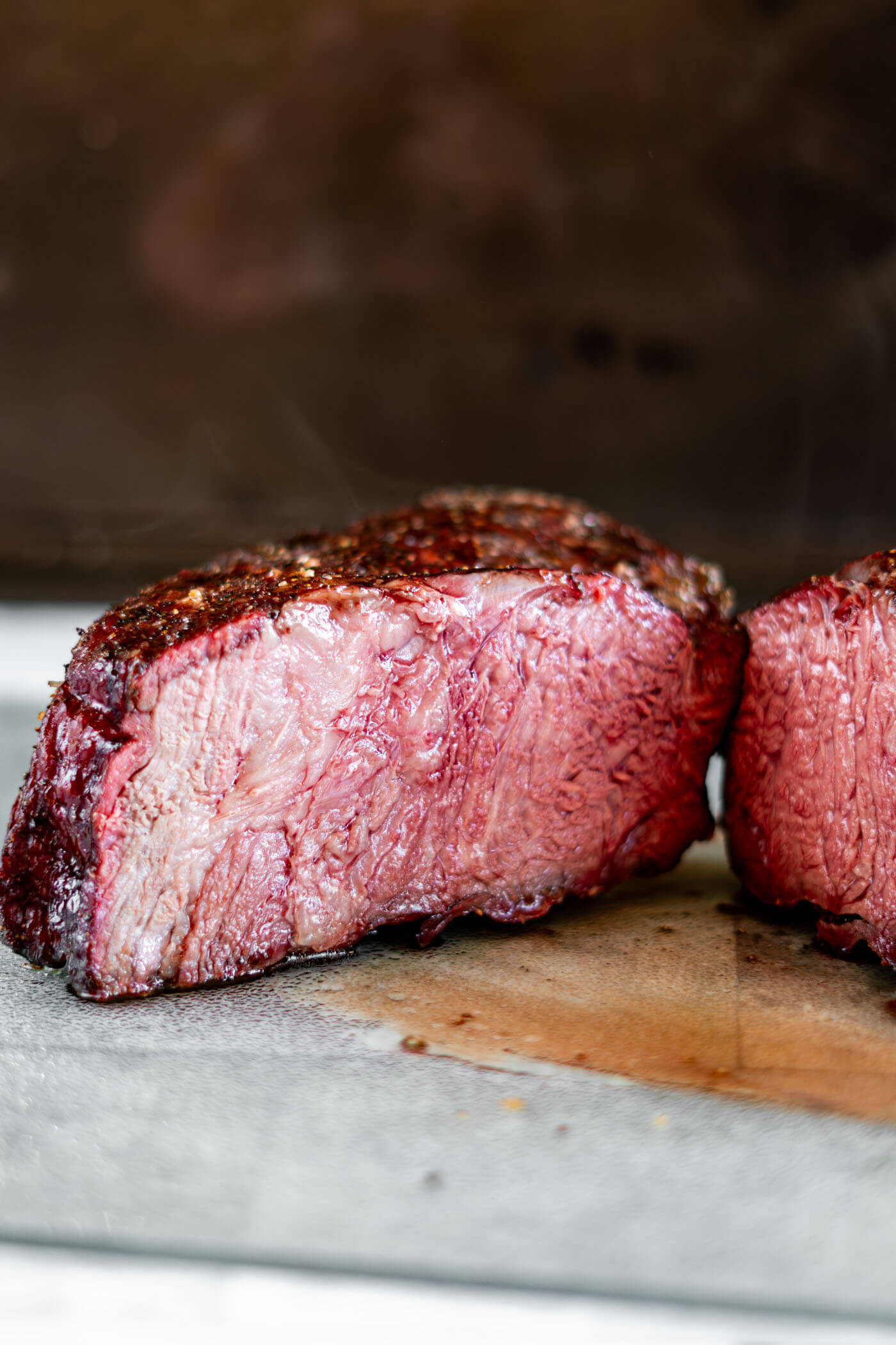 Cross section of the smoked beef roast, showing the tender inside meat, dark smoke ring along the edge and crusted bark.