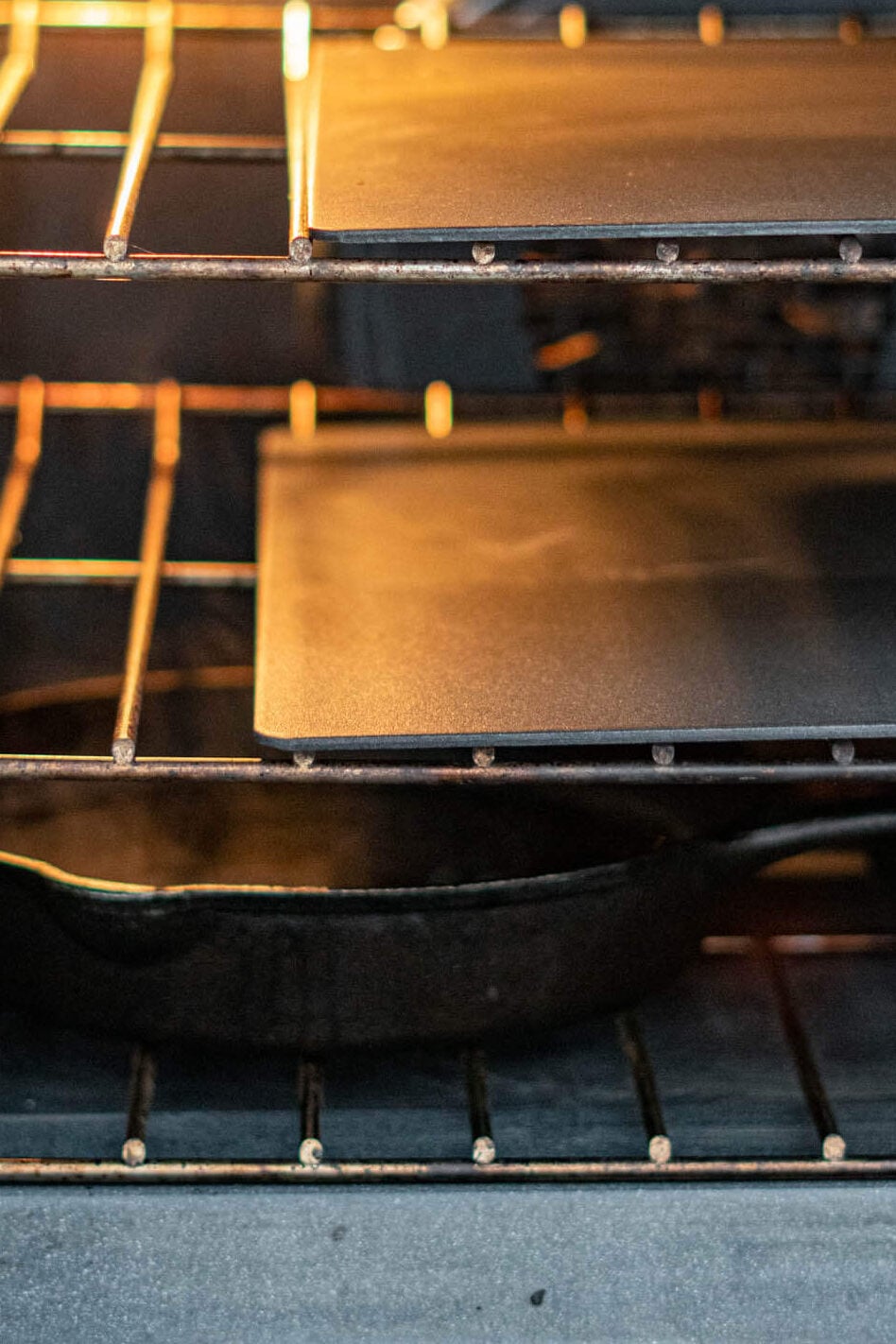 An oven with 2 baking steels and a skillet of water.