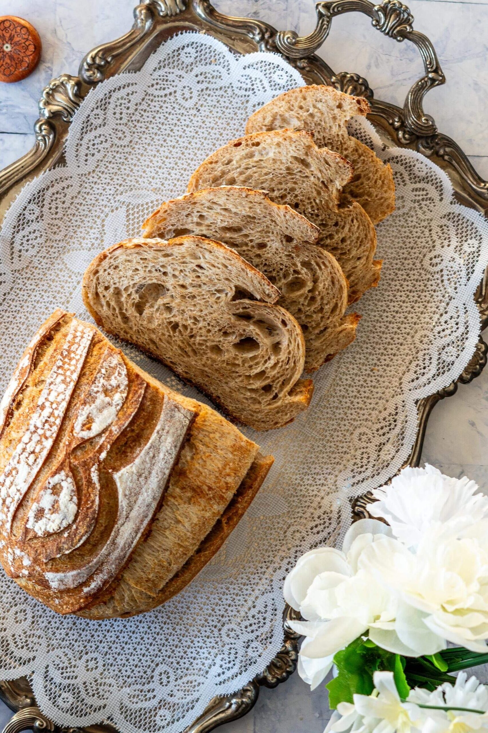 Sliced whole wheat sourdough bread on vintage tray.